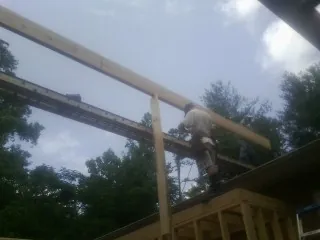 Carpenter setting a ridge beam over a new addition frame — Ice Dam Removal by Roofing Brothers in Ware