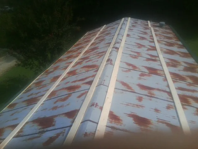 Rusted metal roof panels with new wood purlins before replacement — Storm Damage Roof Repair in Ware by Roofing Brothers