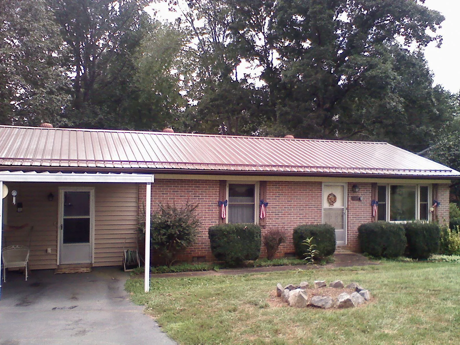 Bronze metal roof and carport on a brick ranch home — Roof Repair work by our crew in Ware